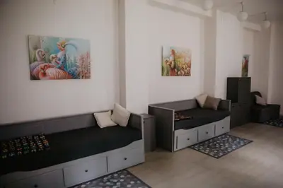 two beds in a room with paintings on the wall at Hillas in Tauragnai