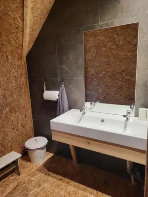 a bathroom with a sink and a toilet and a mirror at Hillas in Tauragnai