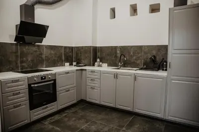 a kitchen with white cabinets and a stove and sink at Hillas in Tauragnai