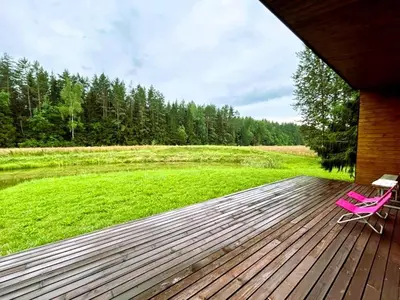 two pink chairs sitting on a wooden deck at Raimundėlio sodyba in Rokiškis