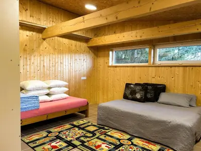 a room with two beds and a rug at Raimundėlio sodyba in Rokiškis