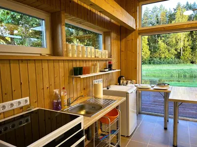 a kitchen with a sink and a table in a cabin at Raimundėlio sodyba in Rokiškis