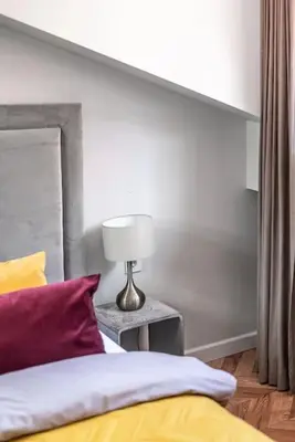 a bedroom with a bed and a lamp on a table at Studio apartment in Oldtown #F in Vilnius