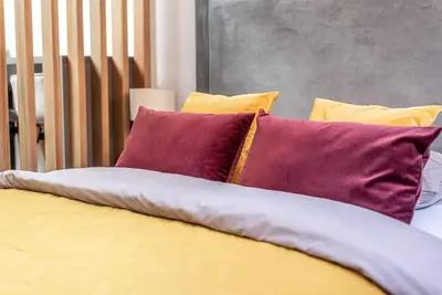 a group of pillows sitting on top of a bed at Studio apartment in Oldtown #F in Vilnius
