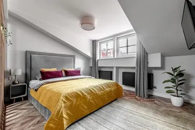 a bedroom with a large bed with a gold bedspread at Studio apartment in Oldtown #F in Vilnius