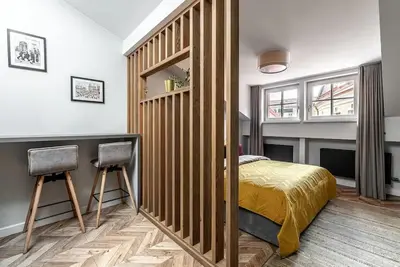a bedroom with a bed and two chairs in it at Studio apartment in Oldtown #F in Vilnius