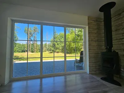an empty living room with a large sliding glass door at Varėnės sodyba in Vėžionys