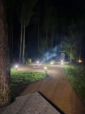 a path in a park at night with lights at Varėnės sodyba in Vėžionys