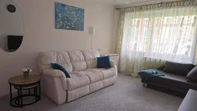 a living room with a white couch and a table at Kristi Apartments in Visaginas