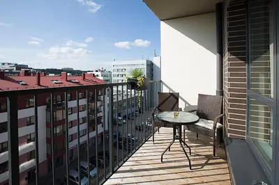 a balcony with a table and chairs on a building at Vita apartment in Vilnius