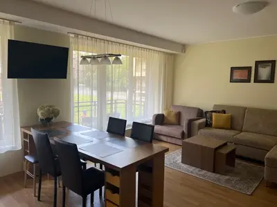 a living room with a dining room table and a couch at Welcome apartment in Druskininkai