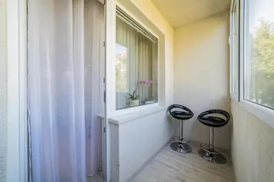a room with two stools sitting next to a window at Amber Apartments in Šiauliai