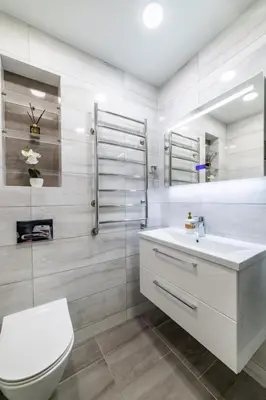 a white bathroom with a toilet and a sink at Amber Apartments in Šiauliai