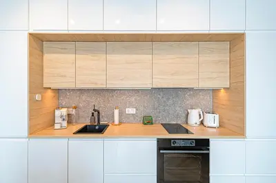 a kitchen with wooden counter tops and white cabinets at Charming 1 BD Apartment by Domvia in Kaunas