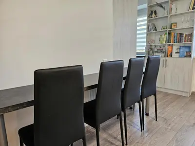 a group of black chairs sitting at a table at Draugyste Apartment in Šiauliai