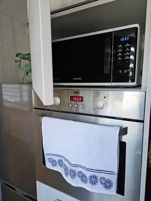 a microwave oven with a towel on the oven at Draugyste Apartment in Šiauliai
