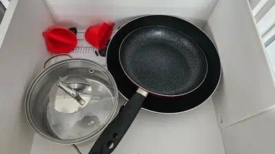a frying pan and a pot in a drawer at Draugyste Apartment in Šiauliai