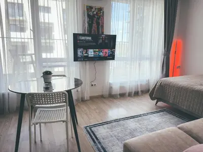 a small living room with a table and a television at Apartment with a large balcony in Kontverki