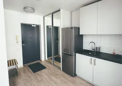 a kitchen with white cabinets and a stainless steel refrigerator at Apartment with a large balcony in Kontverki