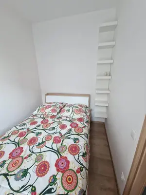 a bedroom with a bed with a floral bedspread at Jaukus butas Pašilaičiuose in Vilnius