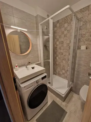 a bathroom with a shower and a sink and a toilet at Jaukus butas Pašilaičiuose in Vilnius