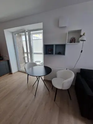 a living room with a table and two chairs at Jaukus butas Pašilaičiuose in Vilnius