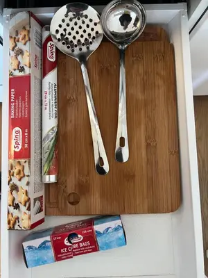 two spoons on a cutting board in a drawer at Modern&bright southwest apartment in Šiauliai