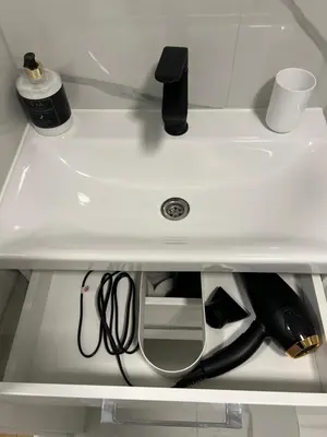 a white sink with a bottle of wine underneath it at Modern&bright southwest apartment in Šiauliai