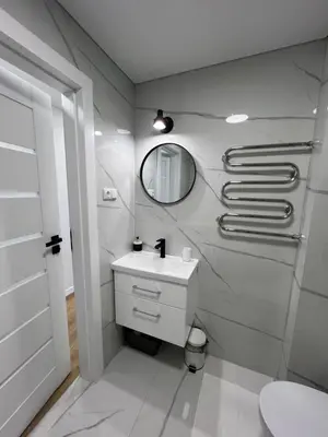 a white bathroom with a sink and a mirror at Modern&bright southwest apartment in Šiauliai
