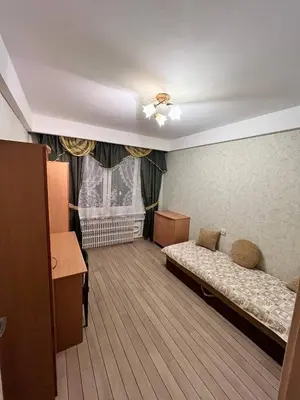 a bedroom with a bed and a desk and a window at Family apartments in Visaginas
