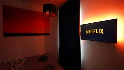 a bedroom with a netflix sign on the wall at Amber Light Self-Check-In Apartments in Kaunas