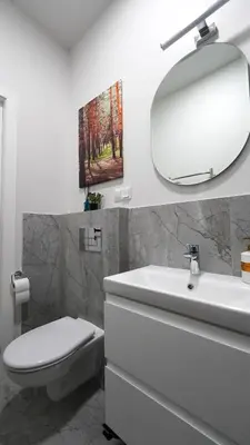 a bathroom with a white sink and a mirror at Amber Light Self-Check-In Apartments in Kaunas