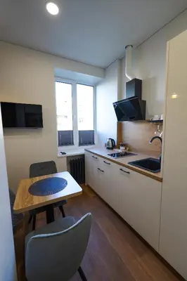 a small kitchen with a table and a table and chairs at Amber Light Self-Check-In Apartments in Kaunas