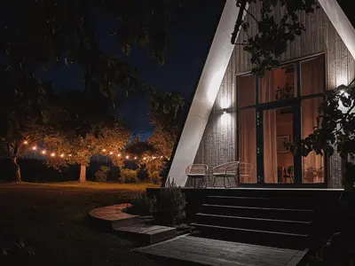 a house with two chairs on the porch at night at Mulberynas in Stakliškės