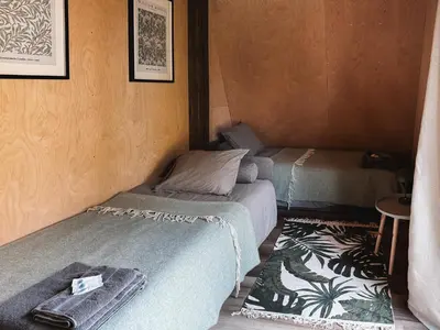 a room with two beds and a table in it at Mulberynas in Stakliškės