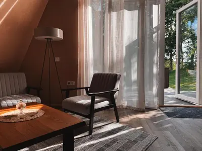 a living room with a chair and a table at Mulberynas in Stakliškės