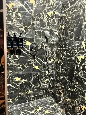 a bathroom with a black and gold marble wall at Jaukūs , modernūs apartamentai in Raseiniai