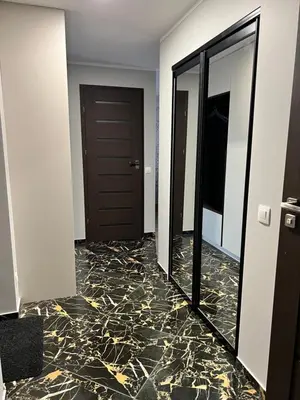 a hallway with a mirror and a door at Jaukūs , modernūs apartamentai in Raseiniai