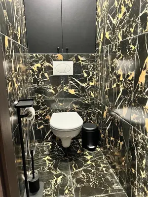 a black and gold bathroom with a toilet in it at Jaukūs , modernūs apartamentai in Raseiniai