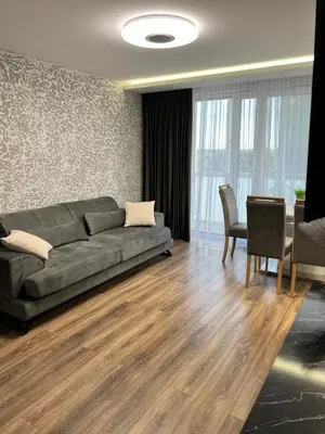 a living room with a couch and a table at Jaukūs , modernūs apartamentai in Raseiniai