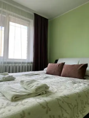 a bedroom with a bed with white sheets and a window at ROŽĖS BUTAS Apartment in Raseiniai