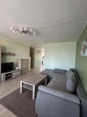 a living room with a couch and a table at ROŽĖS BUTAS Apartment in Raseiniai