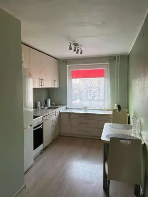a kitchen with white cabinets and a window at ROŽĖS BUTAS Apartment in Raseiniai