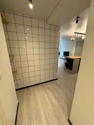 an empty room with white tiled walls and a table at Charming & Central City Escape - Close to Transport in Vilnius