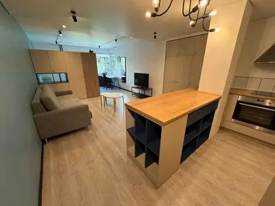 a kitchen and living room with a counter and a couch at Charming & Central City Escape - Close to Transport in Vilnius