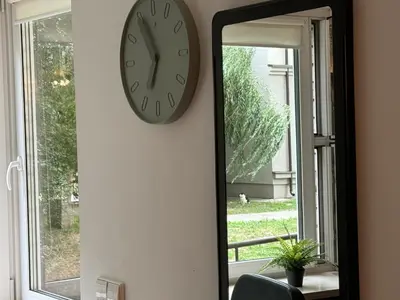 a clock on a wall next to a mirror at Charming & Central City Escape - Close to Transport in Vilnius