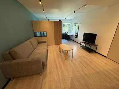 a living room with a couch and a table at Charming & Central City Escape - Close to Transport in Vilnius