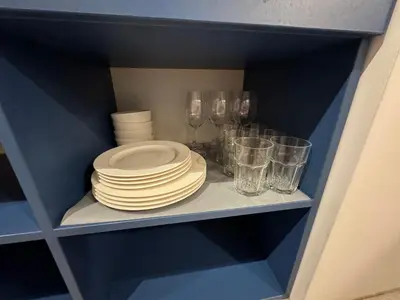 a blue shelf with plates and glasses on it at Charming & Central City Escape - Close to Transport in Vilnius
