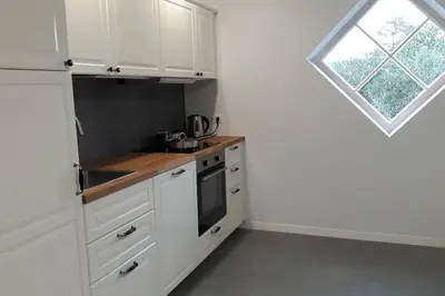 a kitchen with white cabinets and a window at Rami erdvė šalia miško ir ežero darbui ir poilsiui in Trakai