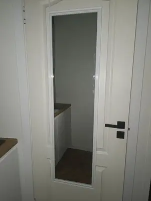 a door with a mirror in a white closet at Pas Alksnius in Šiaudinė